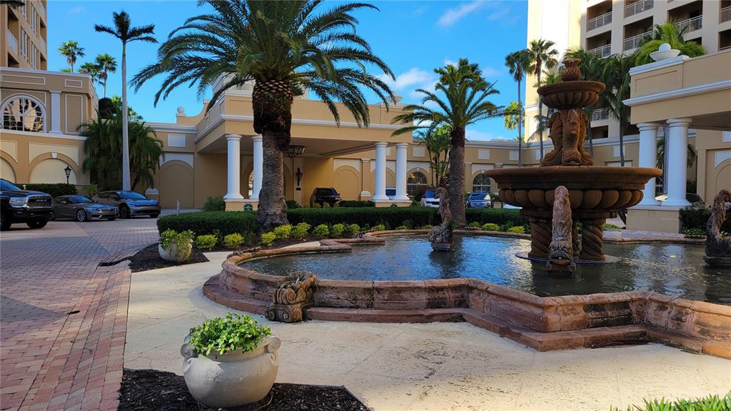 A stone fountain sits in the courtyard of a multi-story building with palm trees — 1111 RITZ CARLTON DRIVE UNIT 1404, SARASOTA, FL