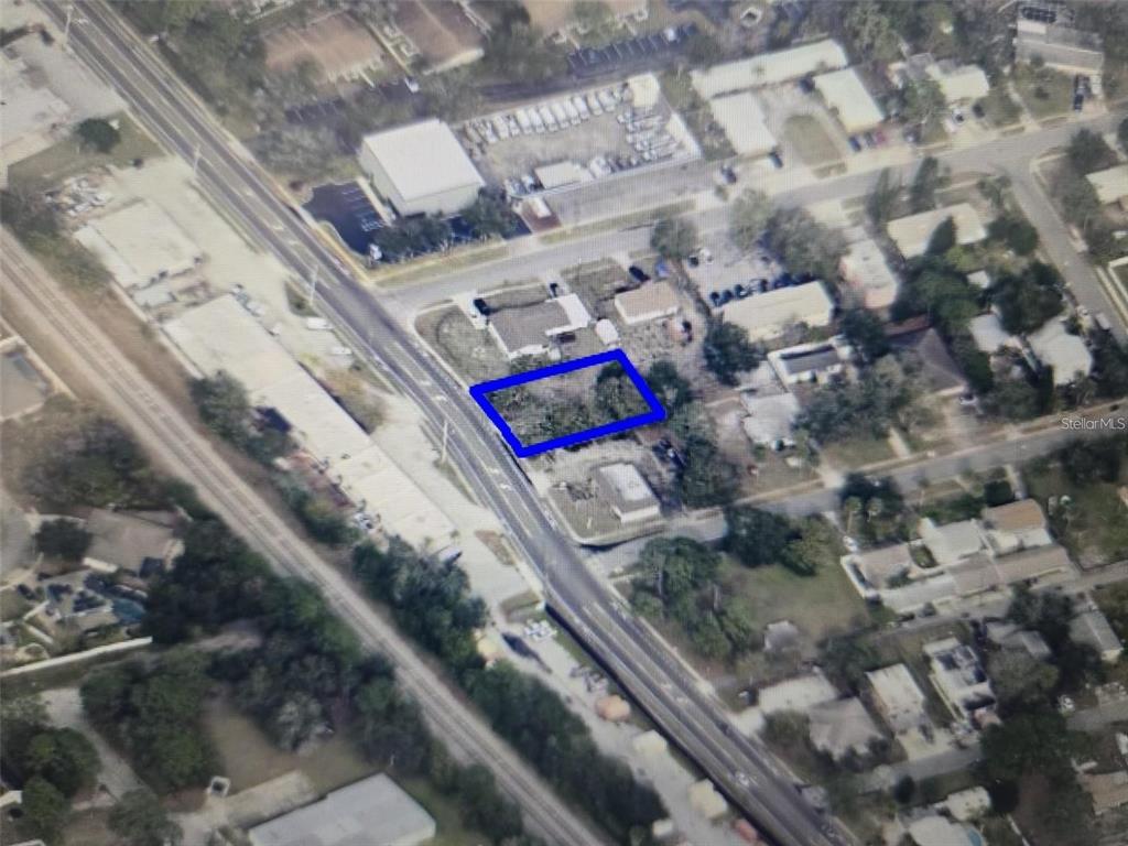 An aerial view shows a vacant, rectangular lot outlined in blue near a road — 3837 S HOPKINS AVENUE, TITUSVILLE, FL