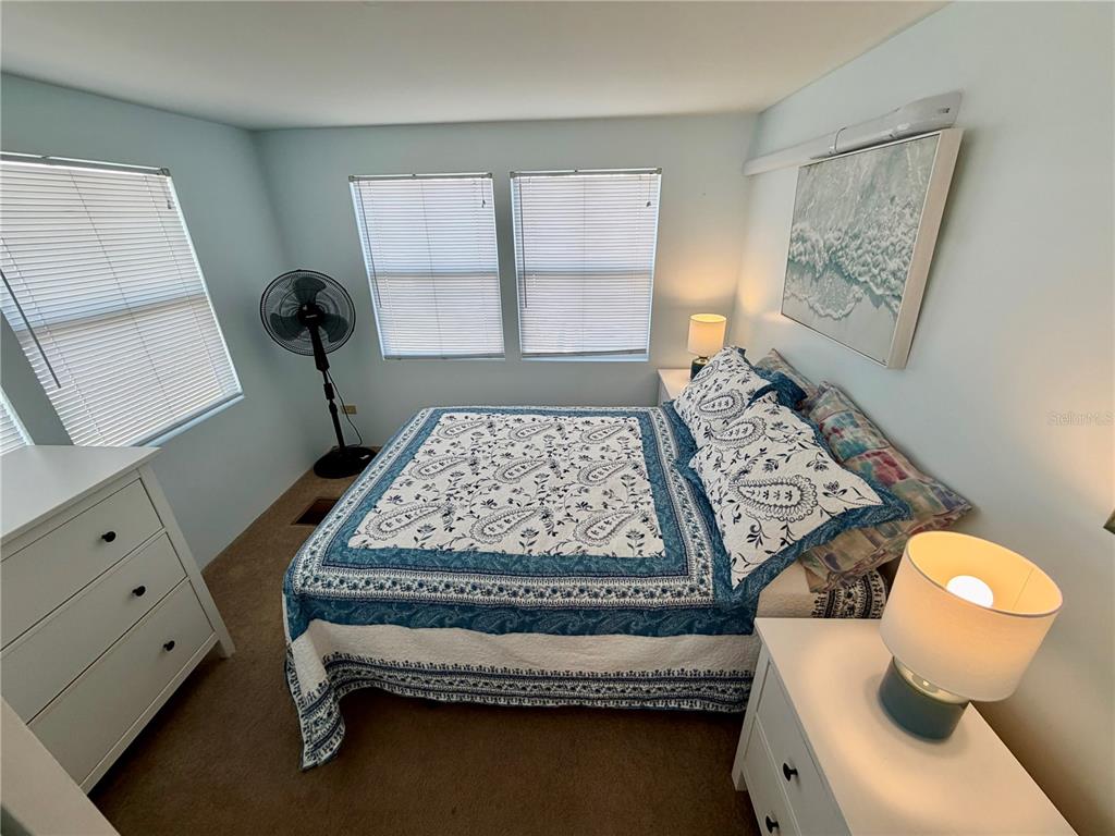 A bedroom features a bed with a blue and white patterned quilt and two nightstands — 34527 VIOLET DRIVE N, PINELLAS PARK, FL