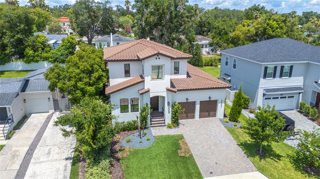 An aerial view shows a two-story stucco house with a brown tile roof and garage — 2403 DERBYSHIRE AVENUE, LAKELAND, FL
