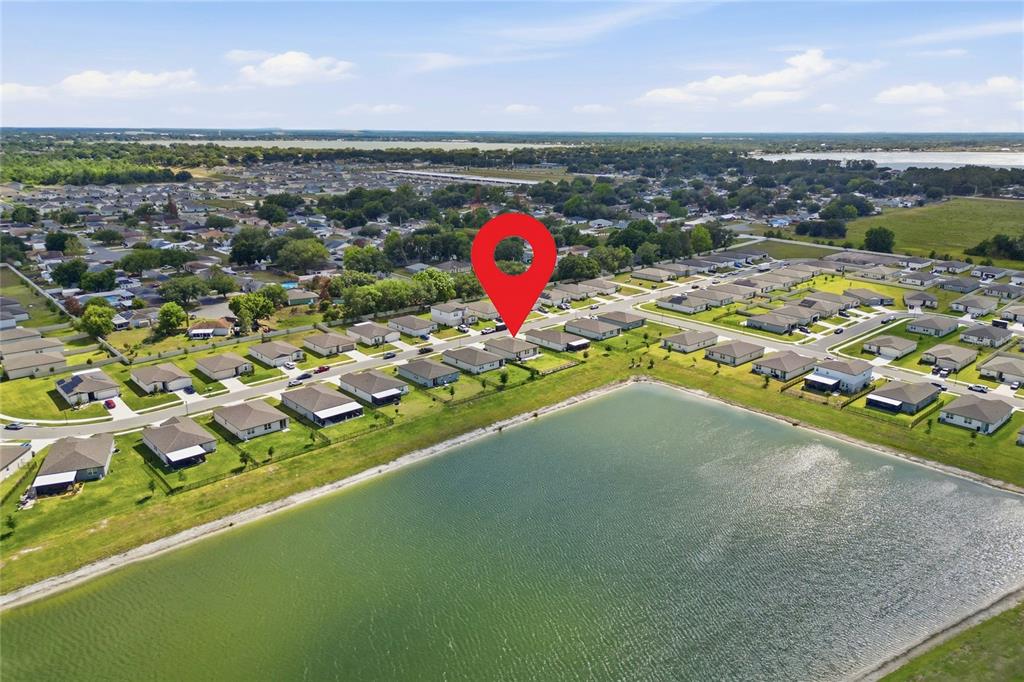 An aerial view shows a suburban neighborhood with a house marked by a red pin — 1256 OAK VALLEY DRIVE, AUBURNDALE, FL