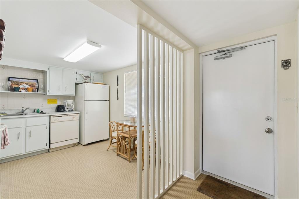 A kitchen with white cabinets, a white refrigerator, and a slatted room divider — 3663 S ATLANTIC AVENUE UNIT 31B, NEW SMYRNA BEACH, FL
