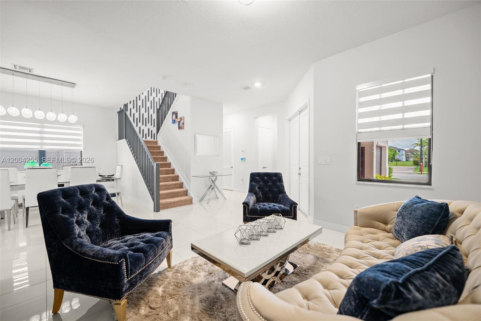 A living room features a tufted beige sofa, two navy velvet armchairs, and a staircase — 4366 SW 174th Ave, Miramar FL 33029, MIRAMAR, FL