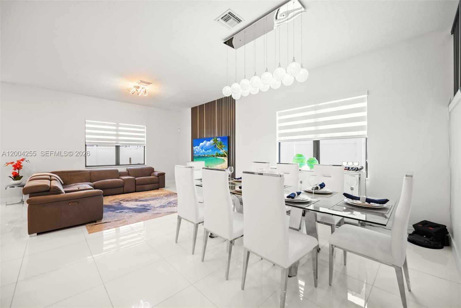 A bright, open-concept living and dining room features white tile floors and modern furniture — 4366 SW 174th Ave, Miramar FL 33029, MIRAMAR, FL
