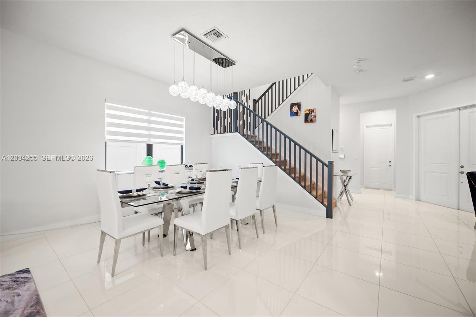 A dining room features a glass table, white chairs, and a staircase with dark railings — 4366 SW 174th Ave, Miramar FL 33029, MIRAMAR, FL