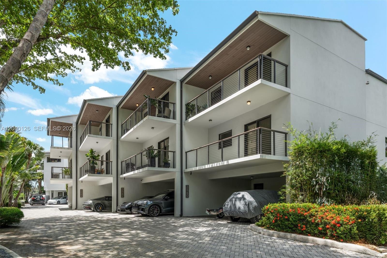A multi-story residential building features covered parking on the ground level and private balconies above — 3560 W Fairview St, Miami FL 33133, MIAMI, FL