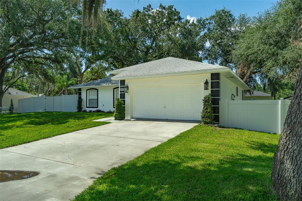 A white single-story house with a two-car garage and a concrete driveway — 930 HICKS ROAD, LAKELAND, FL