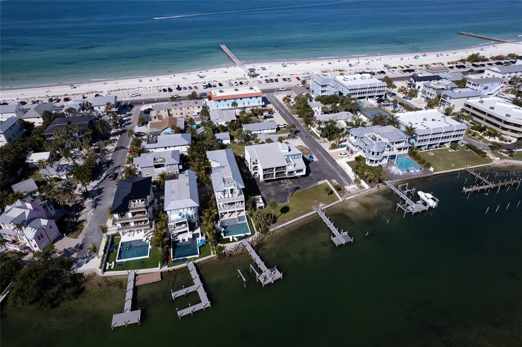 An aerial view shows waterfront homes with private docks along a bay near a beach — 106 11TH STREET S, BRADENTON BEACH, FL