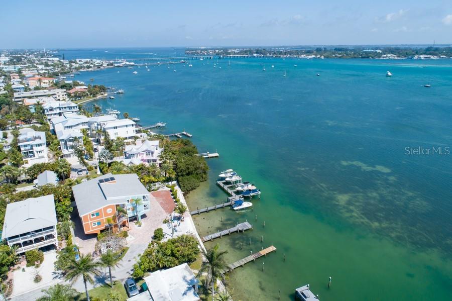 An aerial view shows waterfront homes with private docks and boats along a coastal bay — 106 11TH STREET S, BRADENTON BEACH, FL