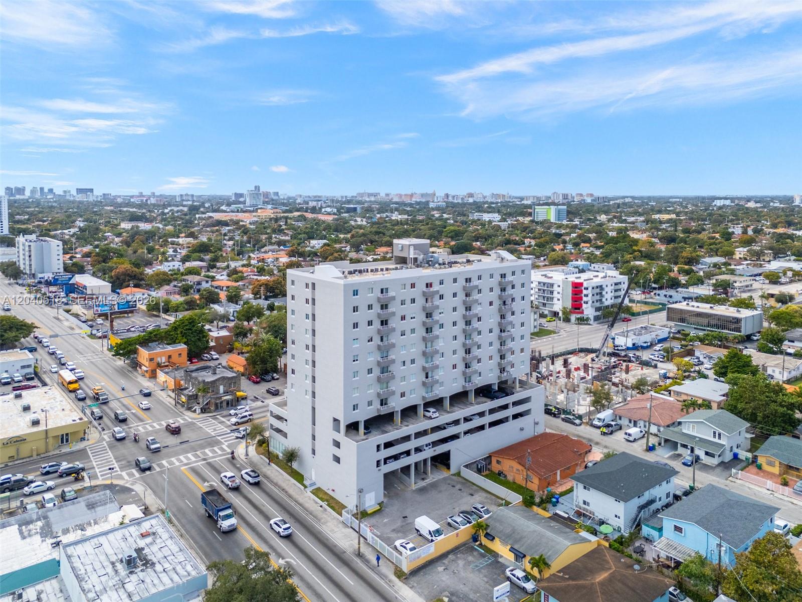 An aerial view shows a tall, light-gray apartment building situated near a busy intersection — 2217 NW 7th St # 1109, Miami FL 33125, MIAMI, FL