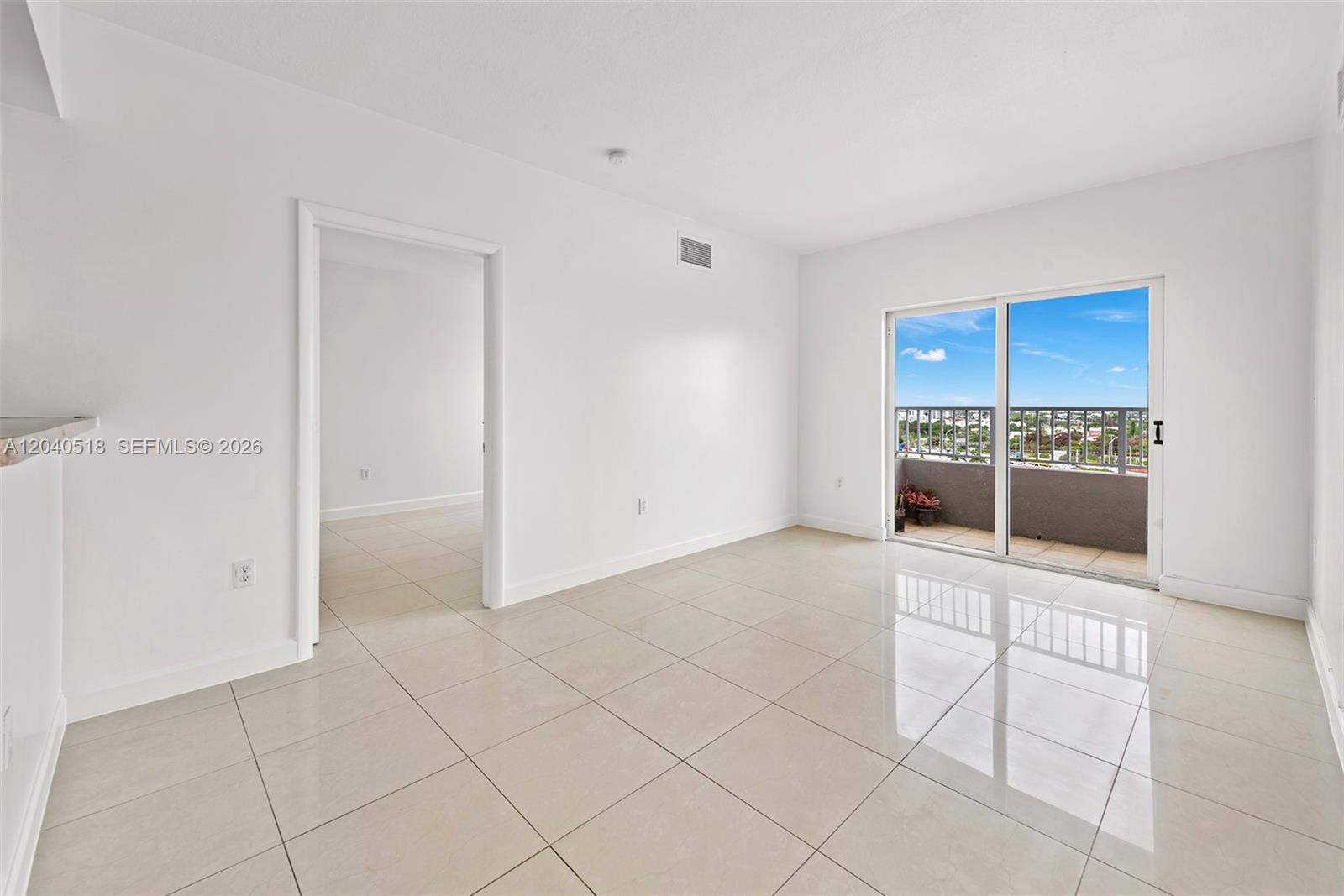 An empty room with white walls, light tile flooring, and a sliding glass door balcony — 2217 NW 7th St # 1109, Miami FL 33125, MIAMI, FL