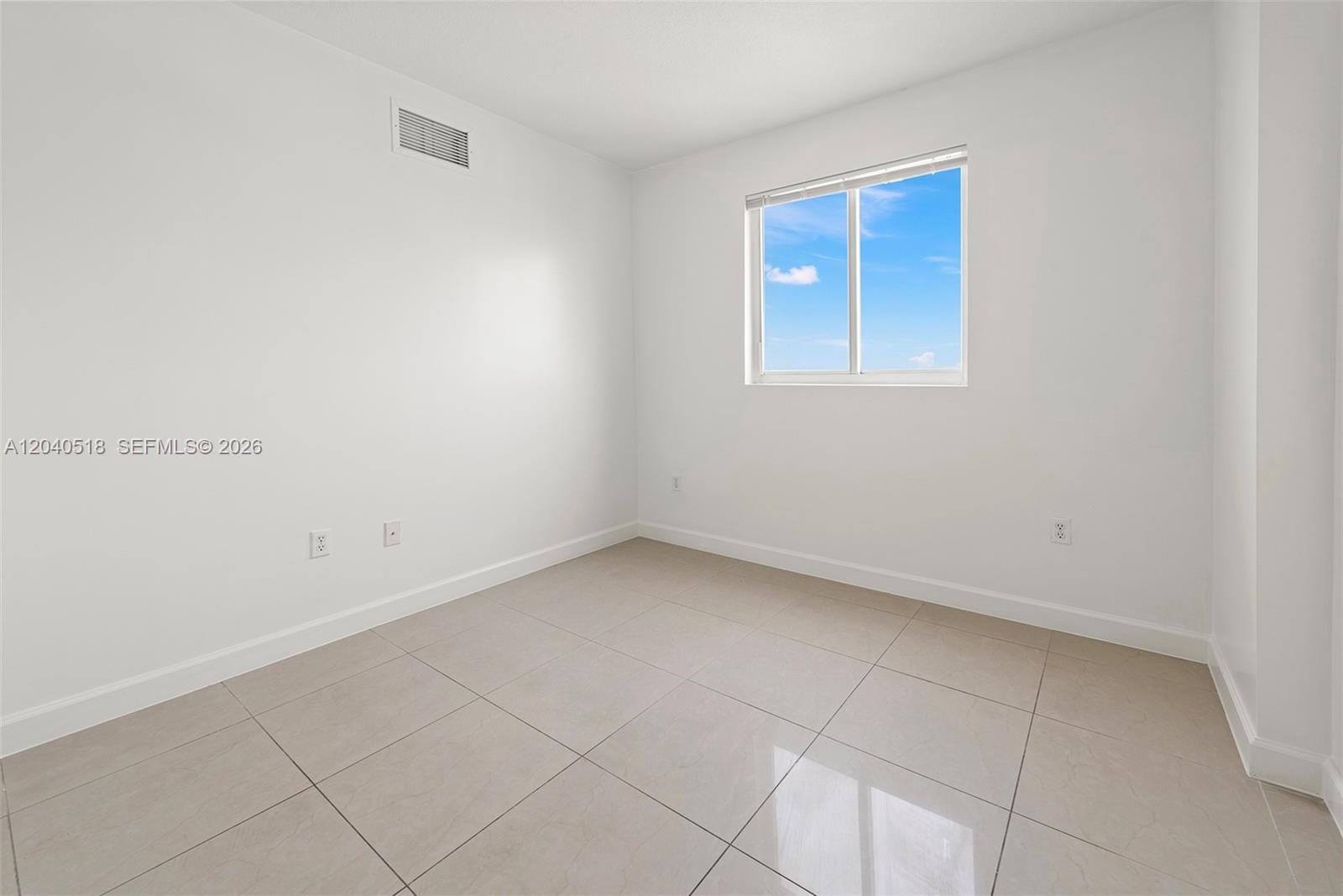 An empty room features white walls, light-colored tile flooring, and a single window — 2217 NW 7th St # 1109, Miami FL 33125, MIAMI, FL
