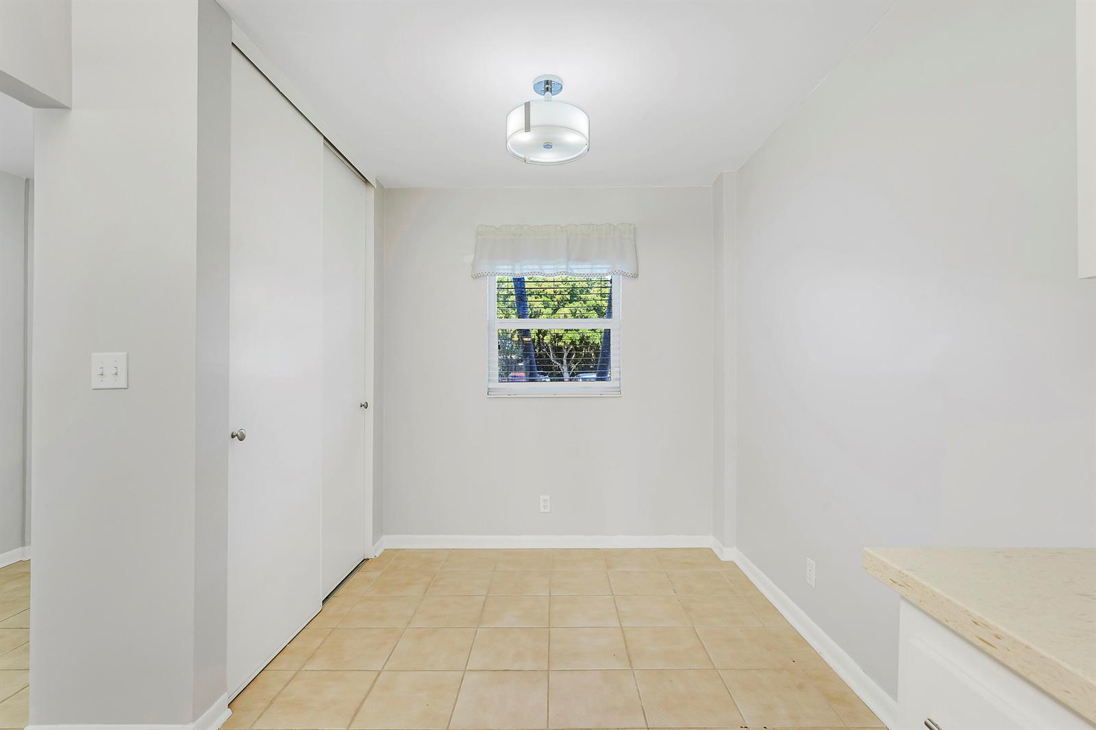 A dining area features light-colored walls, beige tile flooring, a window, and a ceiling light — 3326 Arcara Way # 108, Lake Worth FL 33467, LAKE WORTH, FL