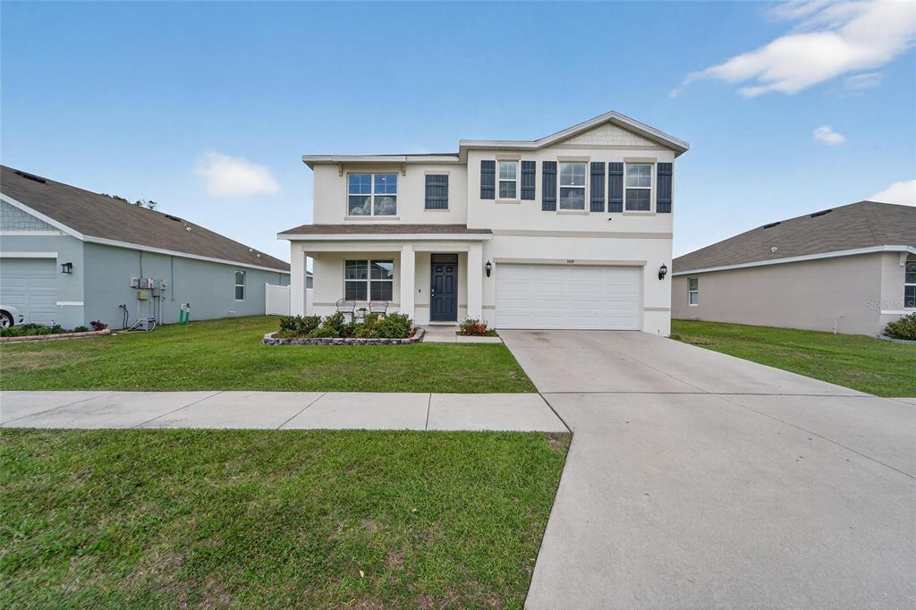 A two-story suburban house with a white stucco exterior, a two-car garage, and a driveway — 3009 BLAKERT COURT, PLANT CITY, FL