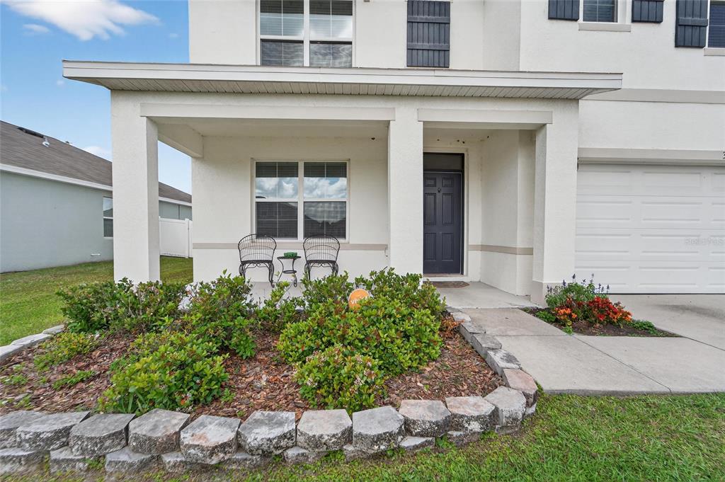 The exterior of a two-story house features a covered front porch, landscaping, and a garage — 3009 BLAKERT COURT, PLANT CITY, FL