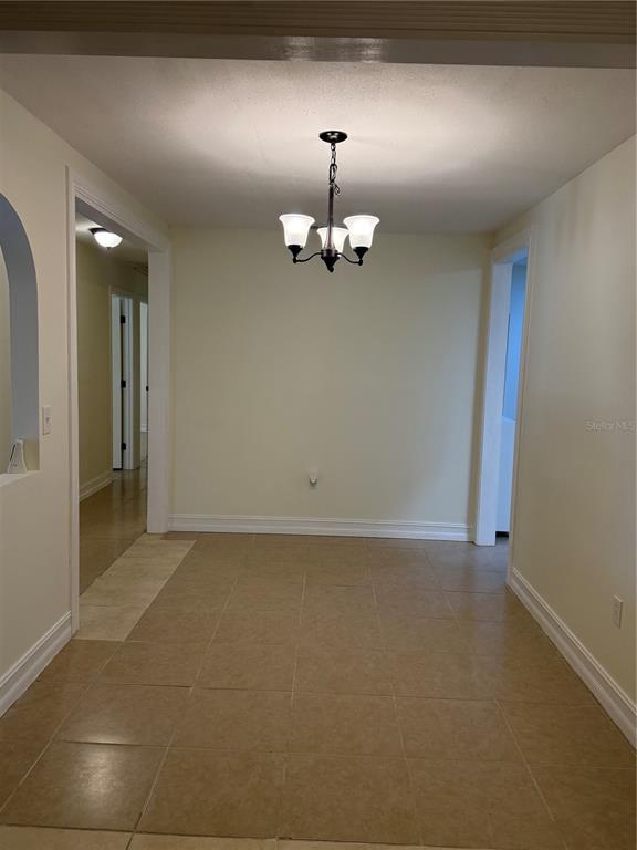 A dining area features tile flooring, a central chandelier, and doorways leading to other rooms — 362 HOLLY RIDGE ROAD, WINTER HAVEN, FL