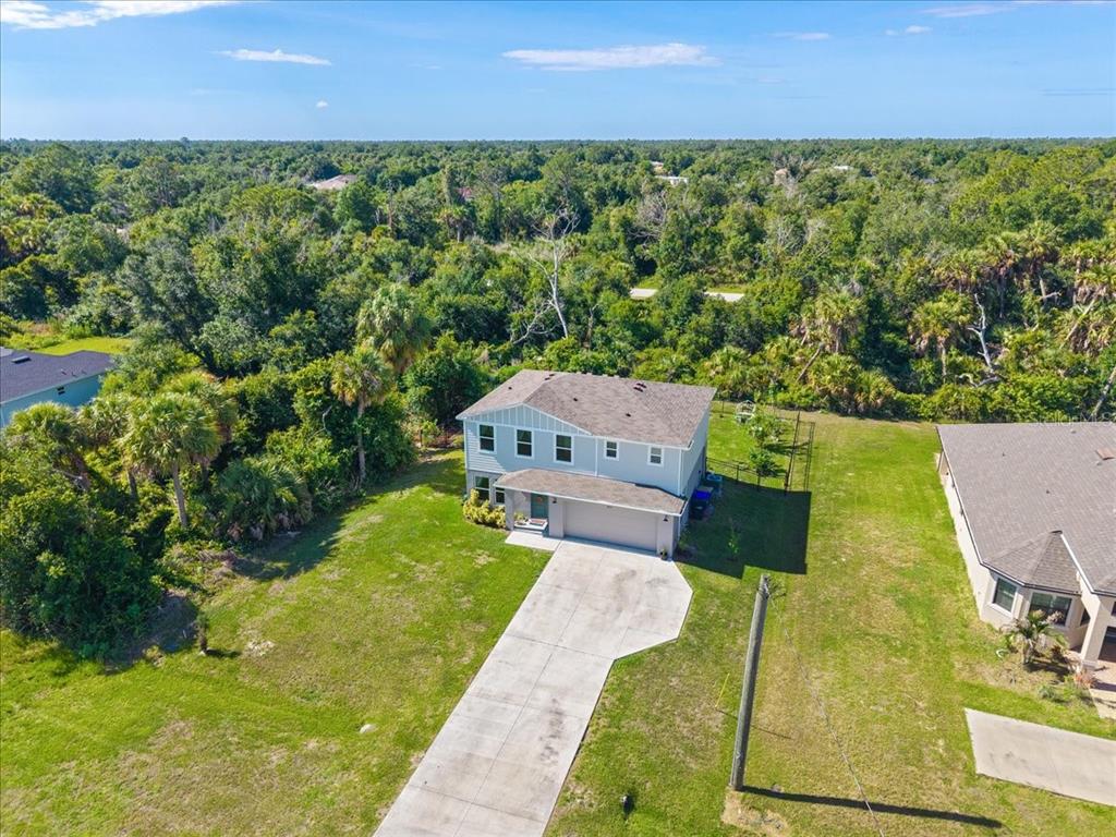 A two-story house with light gray siding, a two-car garage, and a teal front door — 2737 E PRICE BOULEVARD, NORTH PORT, FL