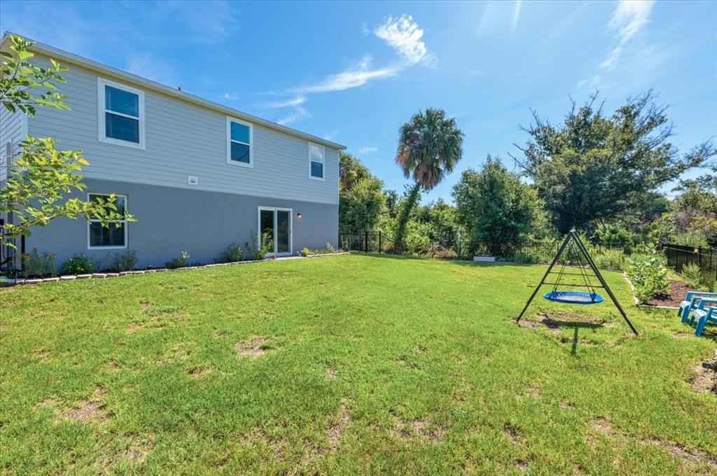 A two-story house with a backyard featuring a swing set and a lawn — 2737 E PRICE BOULEVARD, NORTH PORT, FL