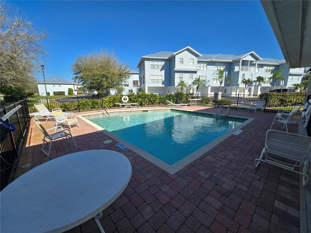 A rectangular swimming pool is surrounded by a brick patio with lounge chairs and tables — 3919 CAPE HAZE DRIVE UNIT 505, ROTONDA WEST, FL