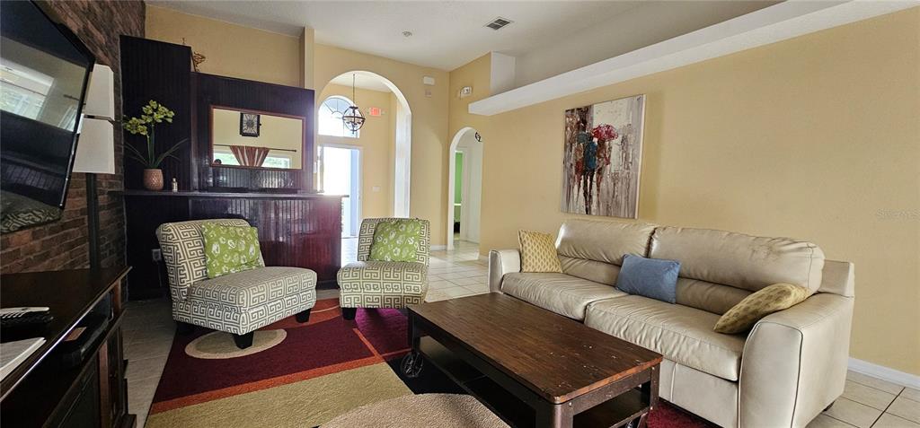 A living room features a beige sofa, two patterned armchairs, and a dark wood coffee table — 195 MINNIEHAHA CIRCLE, HAINES CITY, FL