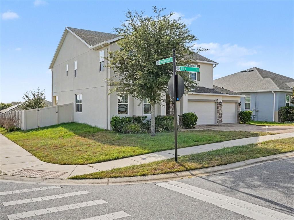 A two-story suburban house sits on a corner lot at a street intersection — 1401 SHIRA ROAD, MINNEOLA, FL