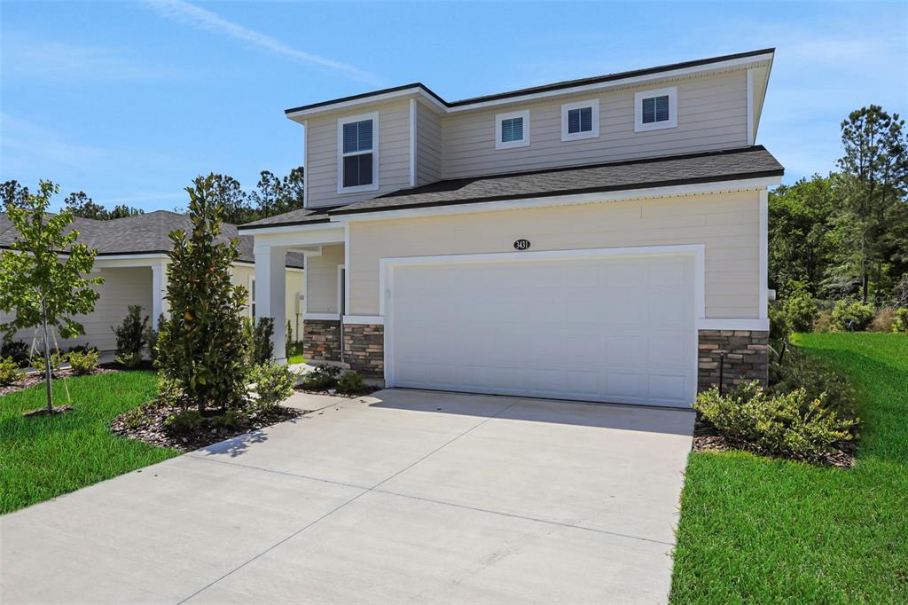 A two-story house with beige siding, a stone-accented base, and a two-car garage — 3431 HUMPHREY STREET, GREEN COVE SPRINGS, FL