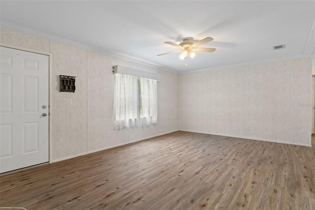 An empty room with light-colored walls, wood-look flooring, a ceiling fan, and a white door — 5351 W ROLLING VIEW PLACE, LECANTO, FL