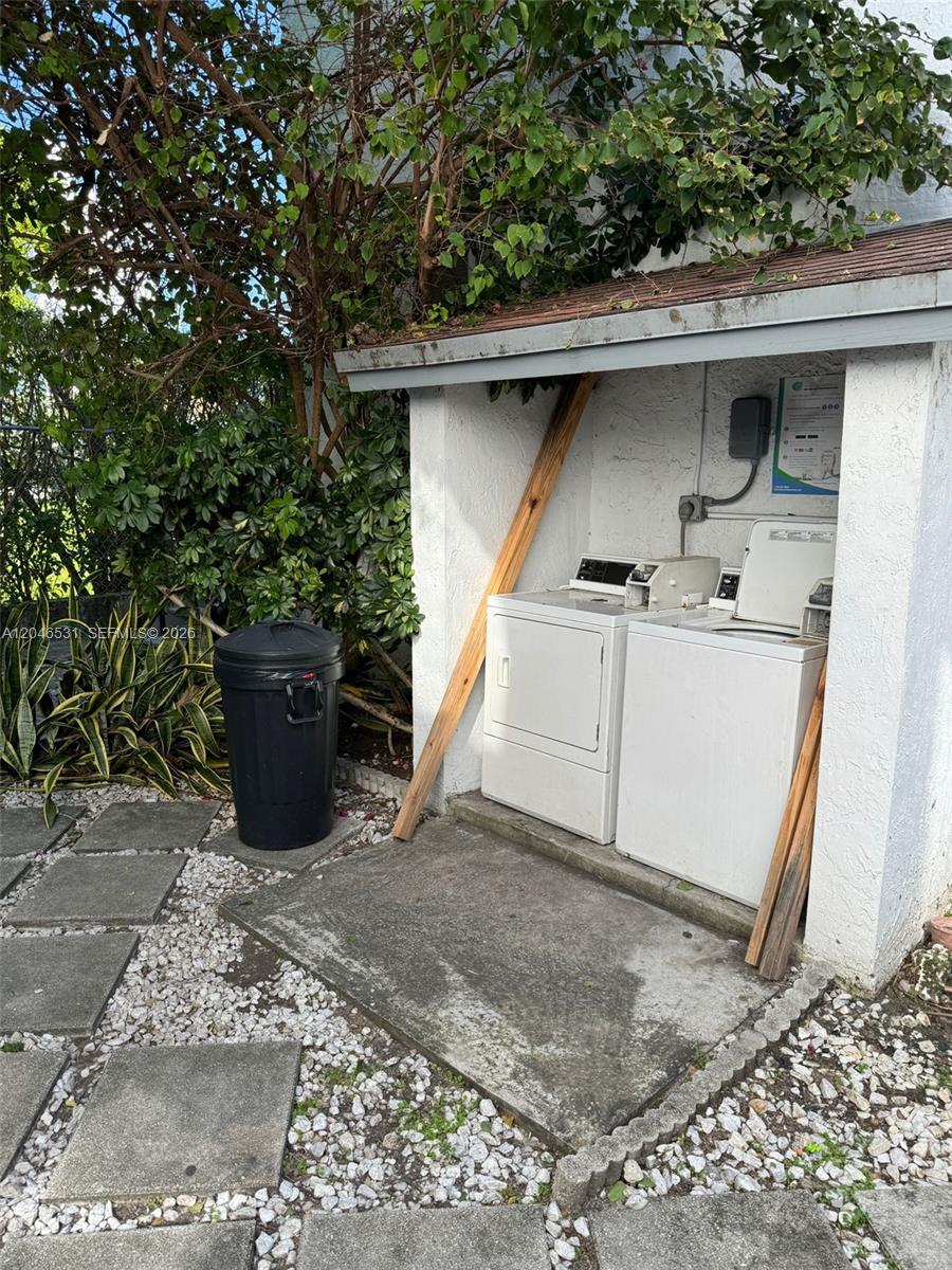 An outdoor laundry area features a washer and dryer under a small, open-sided shelter — 103 NW 6th Ave # 2, Miami FL 33128, MIAMI, FL