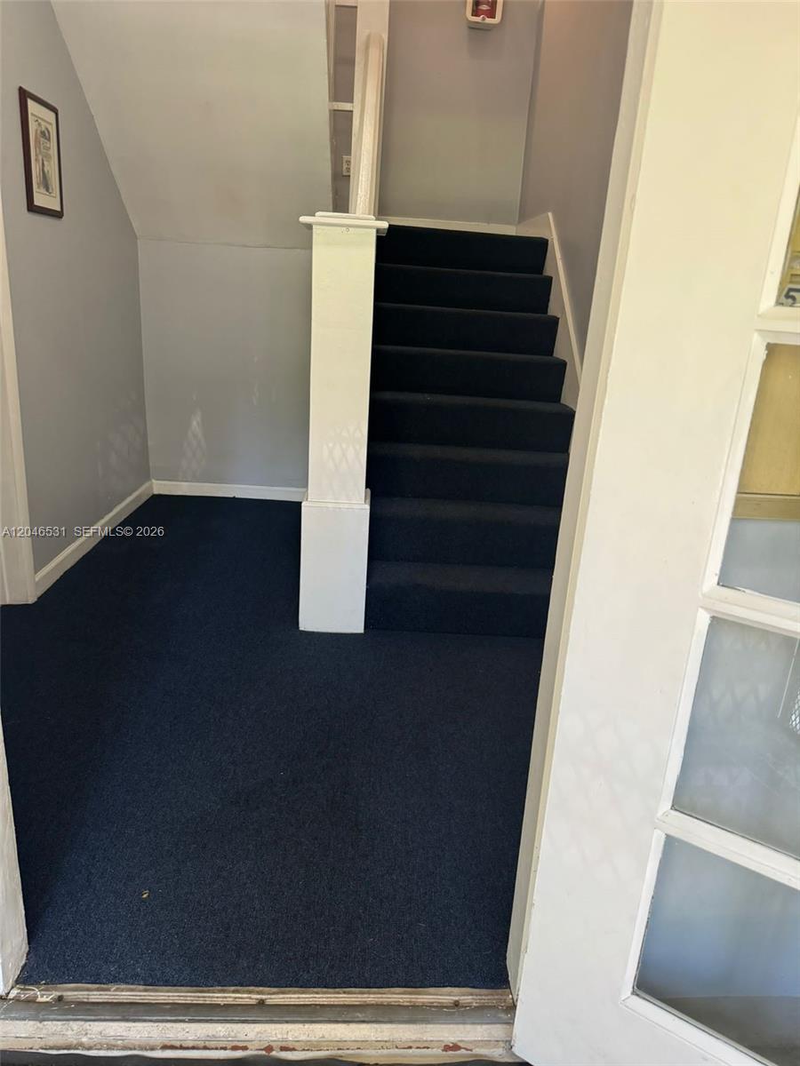 An interior view shows a carpeted entryway with a staircase leading to an upper level — 103 NW 6th Ave # 2, Miami FL 33128, MIAMI, FL
