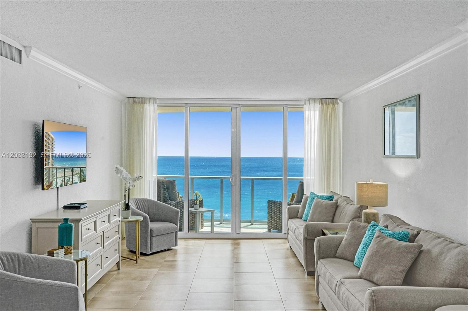 A living room with light tile floors features a balcony overlooking the ocean — 2501 S Ocean Dr, Hollywood FL 33019, HOLLYWOOD, FL