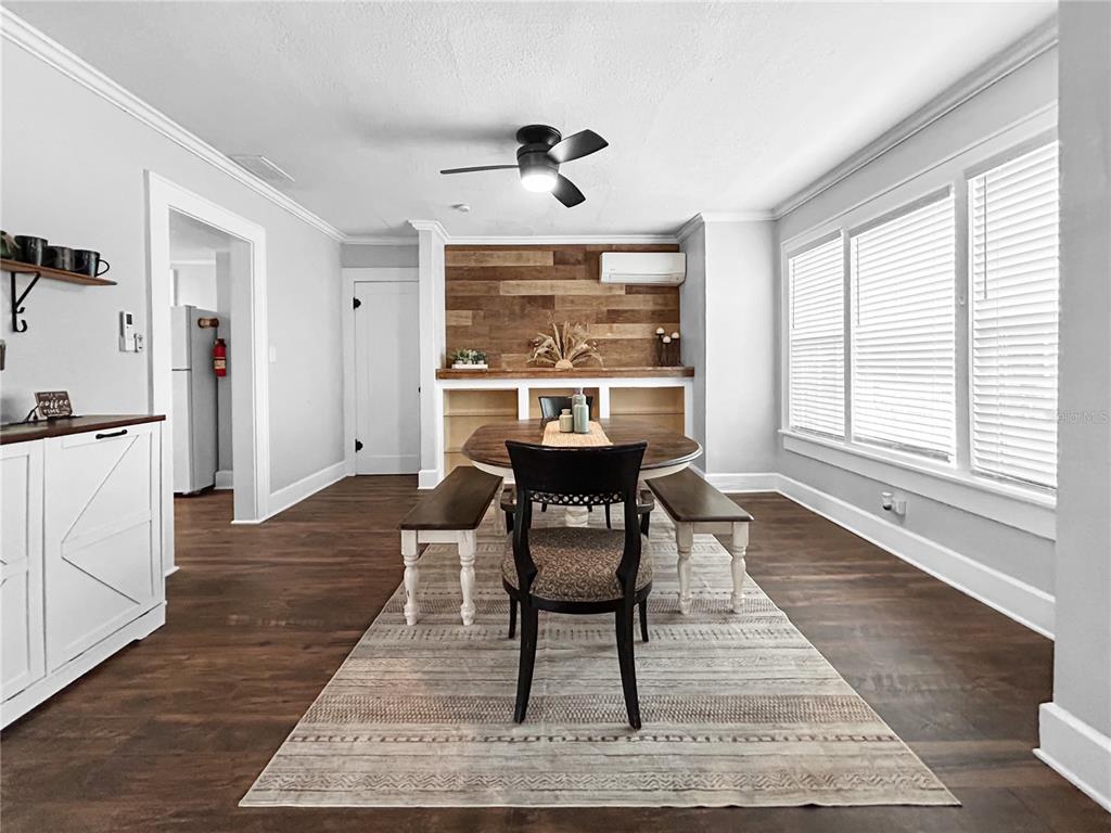 A dining room features a wood-paneled accent wall, a ceiling fan, and a wooden table — 626 37TH AVENUE S, ST PETERSBURG, FL