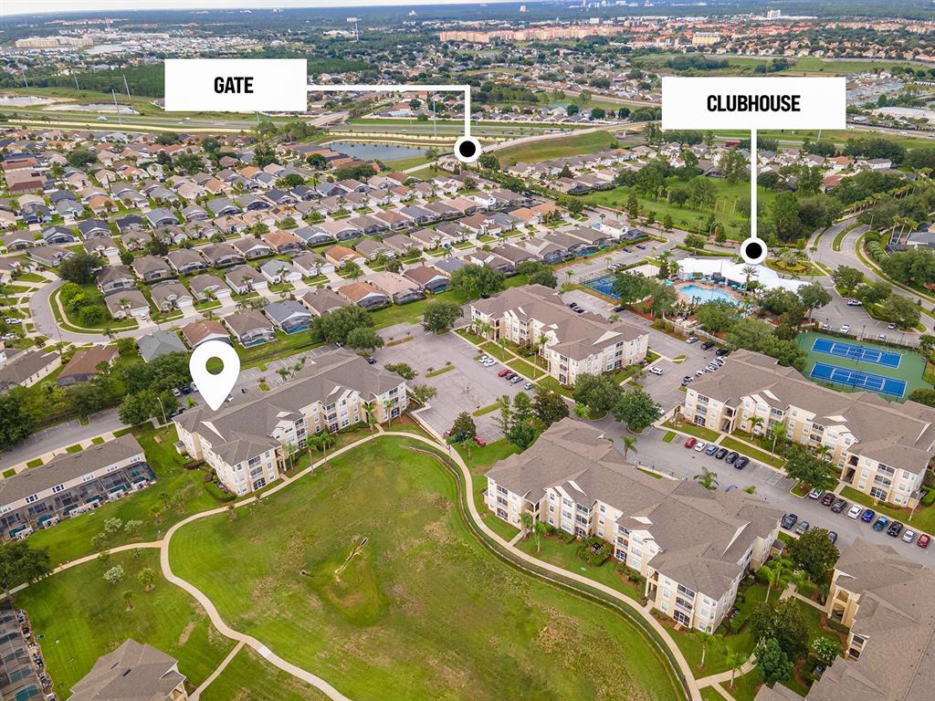 This aerial view shows apartment buildings, a clubhouse, and a gated community — 8102 PRINCESS PALM LANE UNIT #305, KISSIMMEE, FL