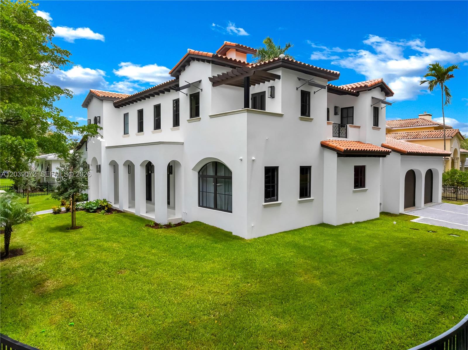 A two-story white stucco house with a red tile roof and arched architectural details — 5111 Alhambra Cir, Coral Gables FL 33146, CORAL GABLES, FL