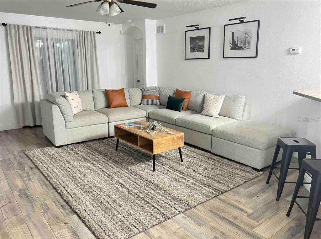 A living room features a large sectional sofa, a wooden coffee table, and a rug — 660 SWALLOWTAIL DRIVE, HAINES CITY, FL