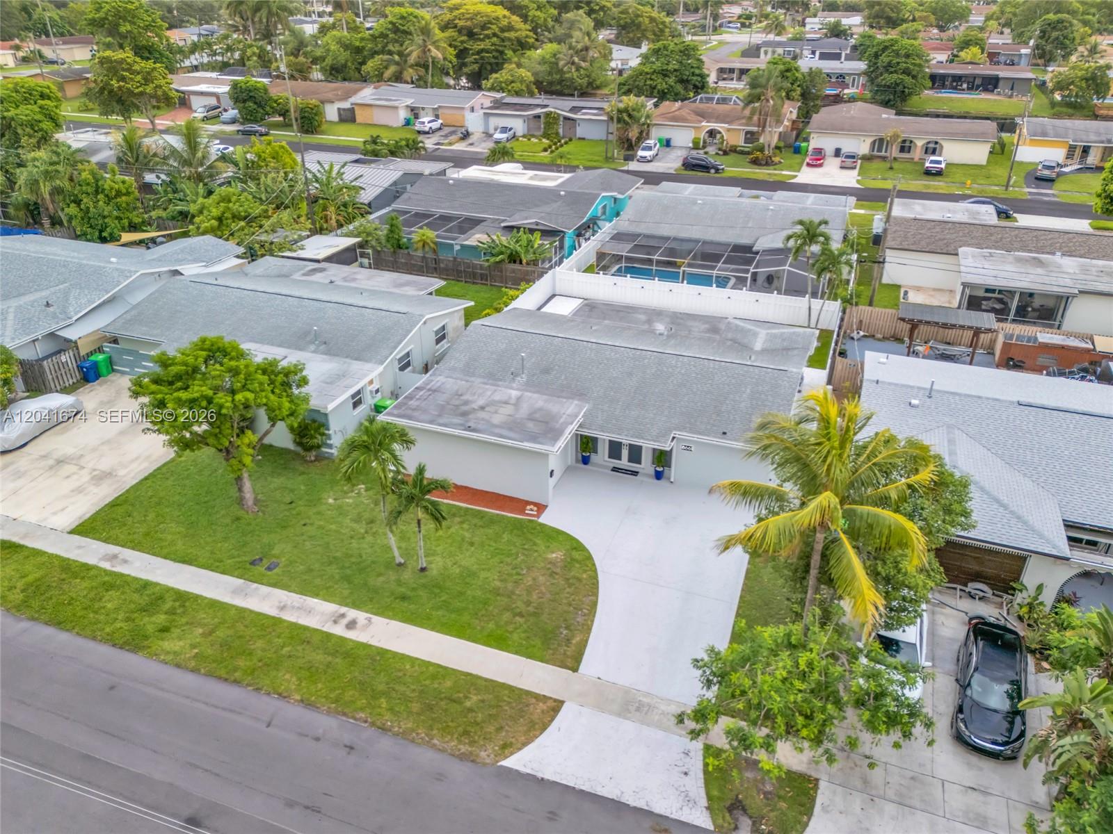 An aerial view shows a single-story house with a white driveway and a green lawn — 8661 NW 20th Ct, Sunrise FL 33322, SUNRISE, FL