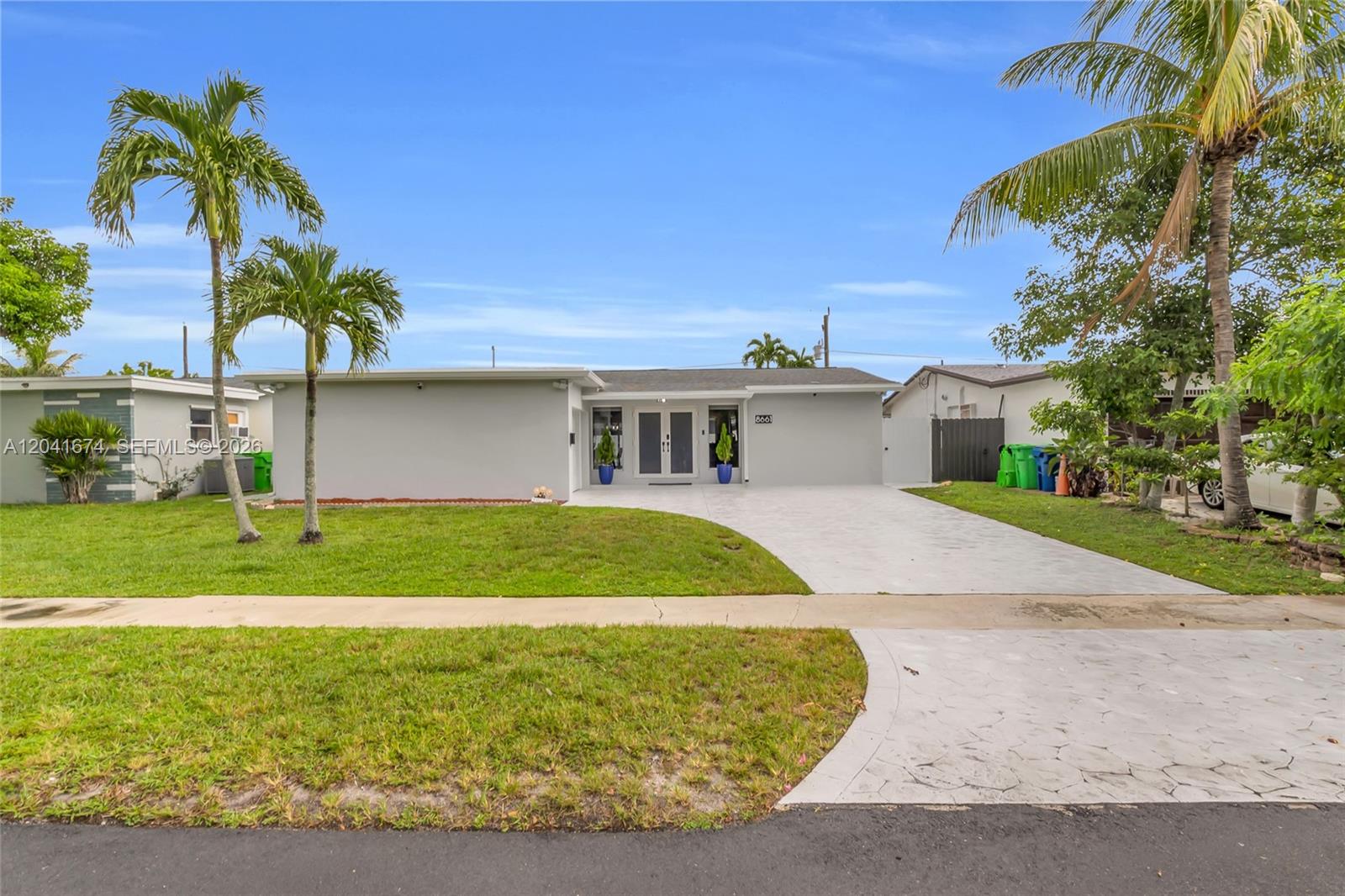 A single-story house with a gray exterior, double front doors, and a concrete driveway — 8661 NW 20th Ct, Sunrise FL 33322, SUNRISE, FL