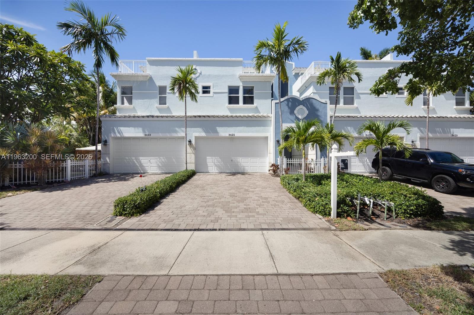 A multi-unit residential building features light blue stucco, white garage doors, and palm trees — 3425 NORFOLK ST, Pompano Beach FL 33062, POMPANO BEACH, FL