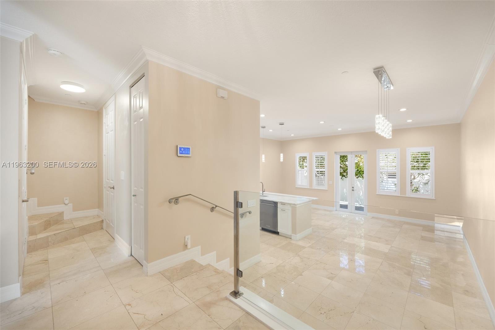 A bright, open-concept kitchen and living area features light tile flooring and glass railings — 3425 NORFOLK ST, Pompano Beach FL 33062, POMPANO BEACH, FL