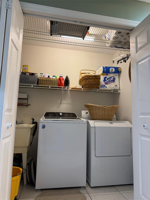 A laundry closet contains a washer, dryer, utility sink, and wire shelving — 9814 OSLIN STREET, TAMPA, FL