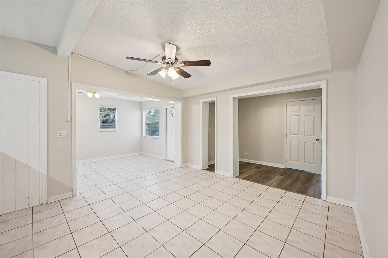 A living area with white tile floors, a ceiling fan, and two adjacent rooms — 5618 Cinnamon Drive, West Palm Beach FL 33415, WEST PALM BEACH, FL