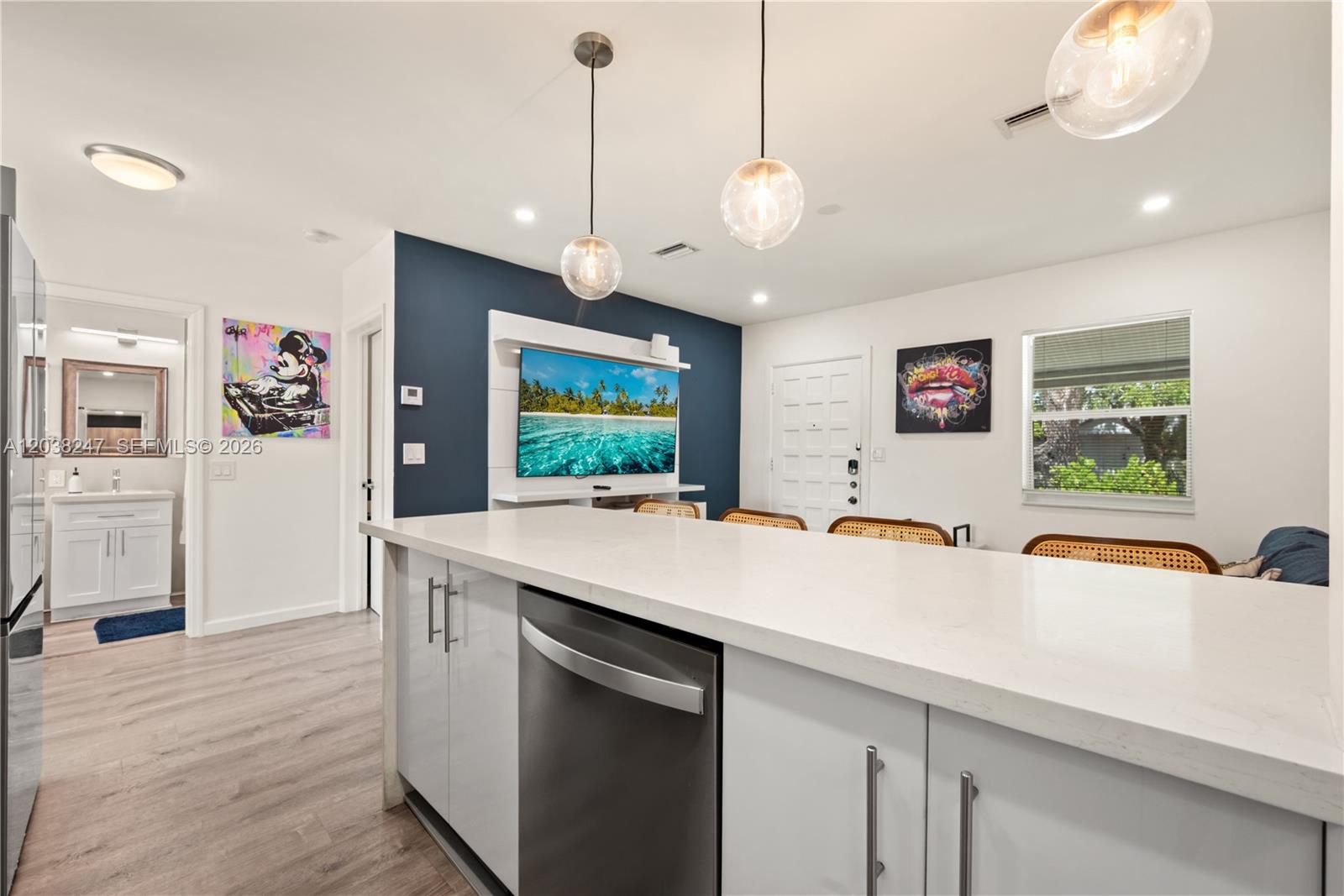 A kitchen island with a white countertop faces a living area with a blue wall — 329 SW 15th Ave, Miami FL 33135, MIAMI, FL