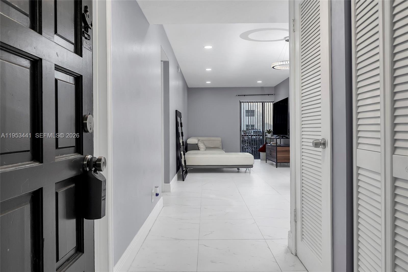 An entryway leads into a living room with white tile floors and a white sofa — 3300 Spanish Moss Ter # 106, Lauderhill FL 33319, LAUDERHILL, FL
