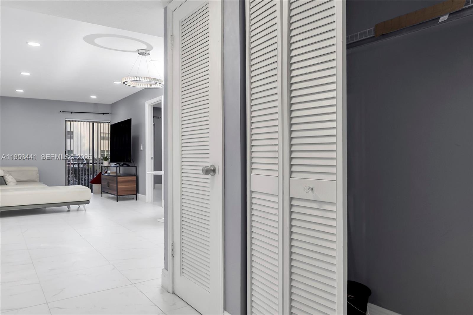 A white louvered closet door stands in a room with gray walls and tile flooring — 3300 Spanish Moss Ter # 106, Lauderhill FL 33319, LAUDERHILL, FL
