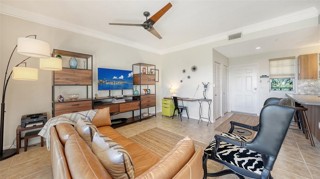 A living room features a leather sofa, a media console, a desk, and a zebra-print chair — 1268 11TH STREET UNIT 2403, SARASOTA, FL