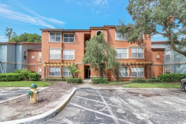 A three-story orange apartment building with a parking lot and fire hydrant in front — 5160 CONROY ROAD UNIT 21, ORLANDO, FL