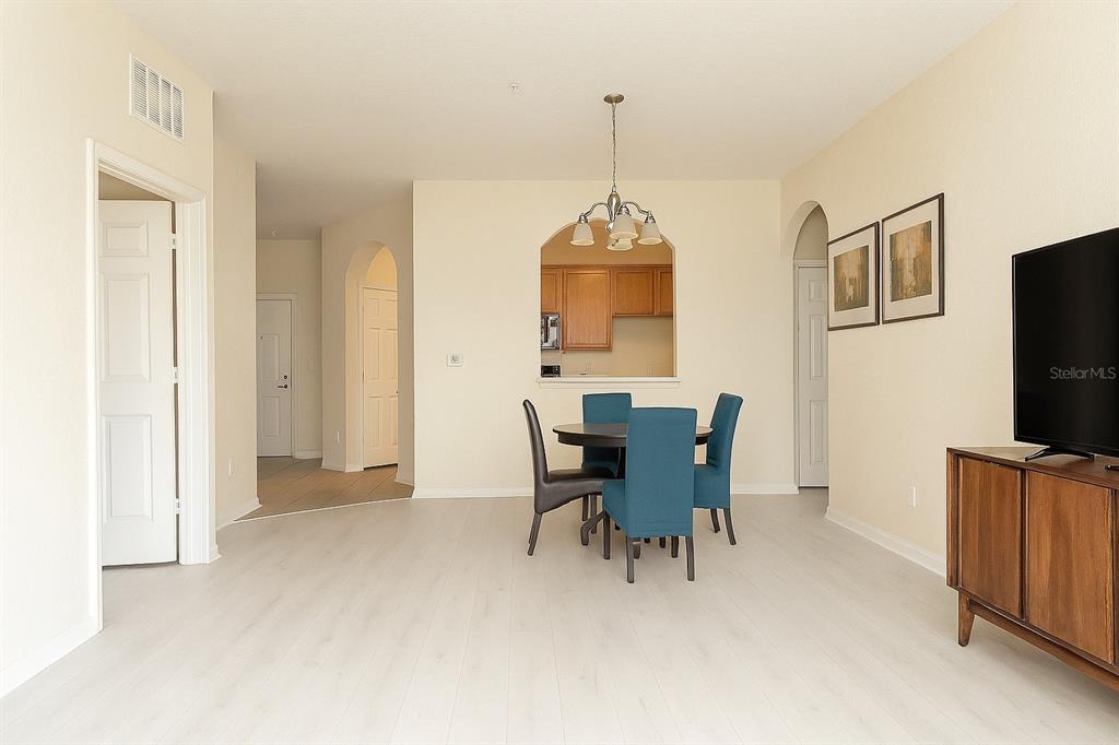 A dining area with a table, four blue chairs, and a view into the kitchen — 3326 ROBERT TRENT JONES DRIVE UNIT 10402, ORLANDO, FL