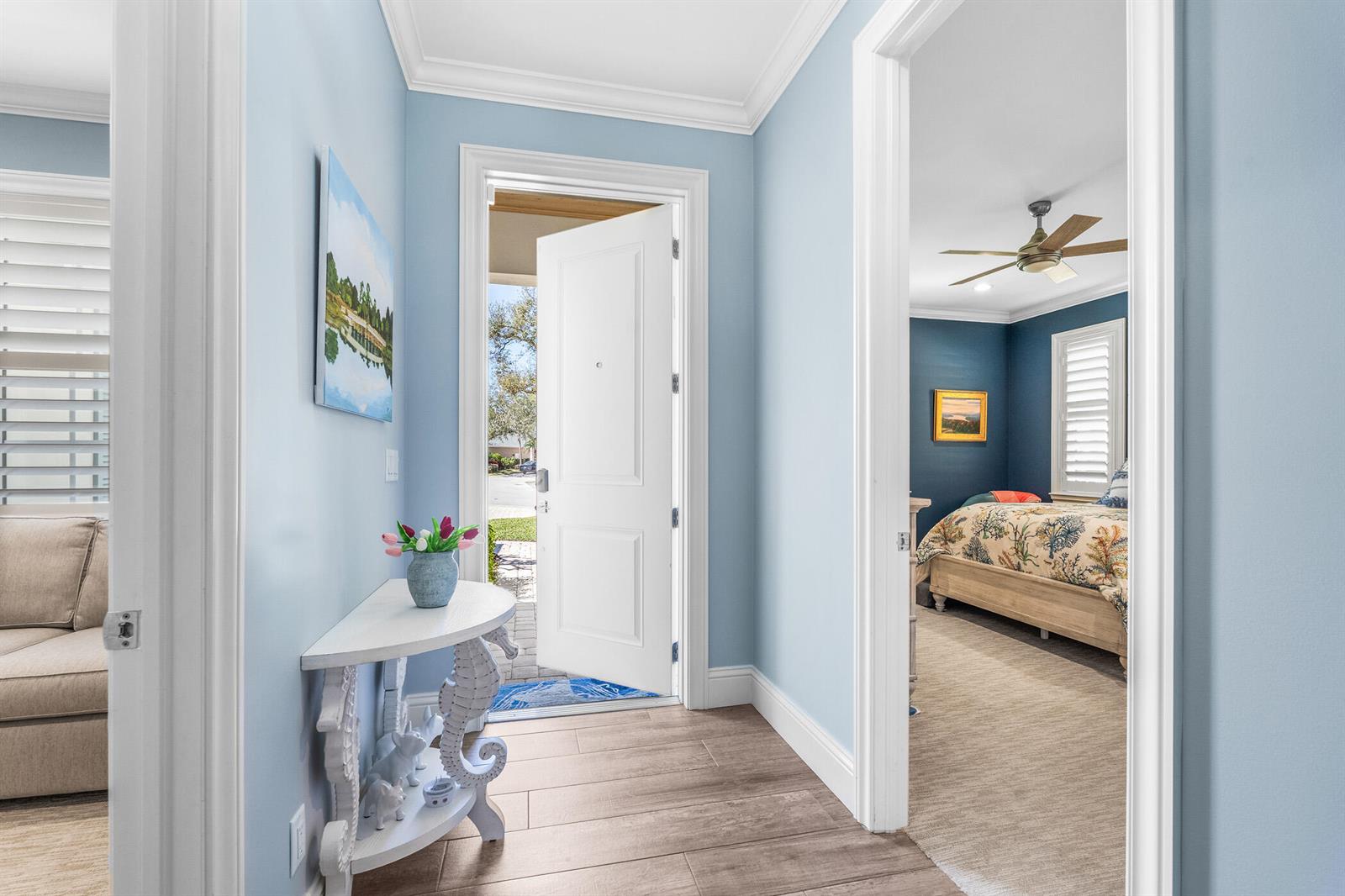 A light blue entryway features a white seahorse console table and an open front door — 605 Bridgewater Lane SW, Vero Beach FL 32962, VERO BEACH, FL