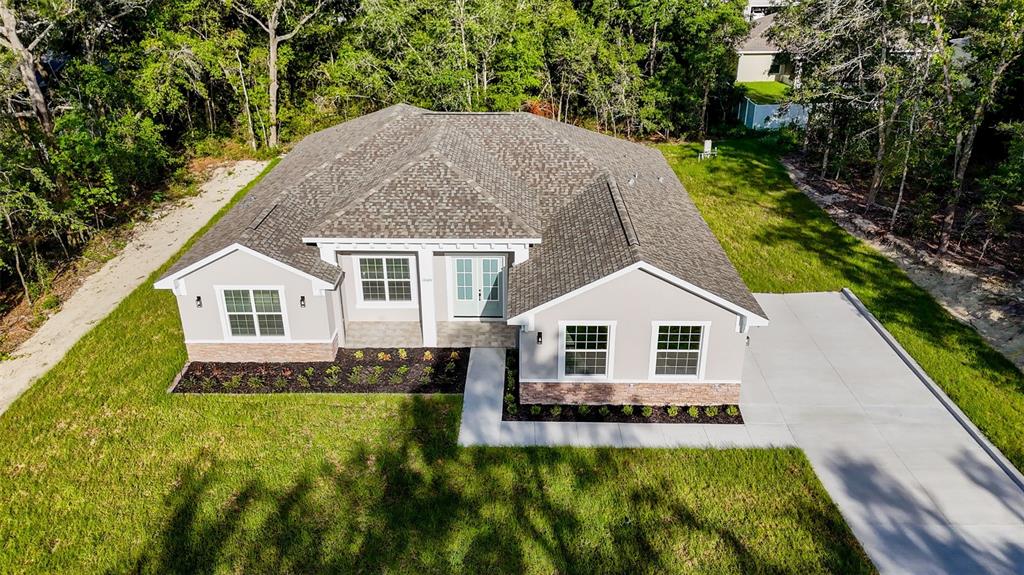 An aerial view of a single-story house with a gray roof and light-colored siding — 16324 SE 88TH AVENUE, SUMMERFIELD, FL