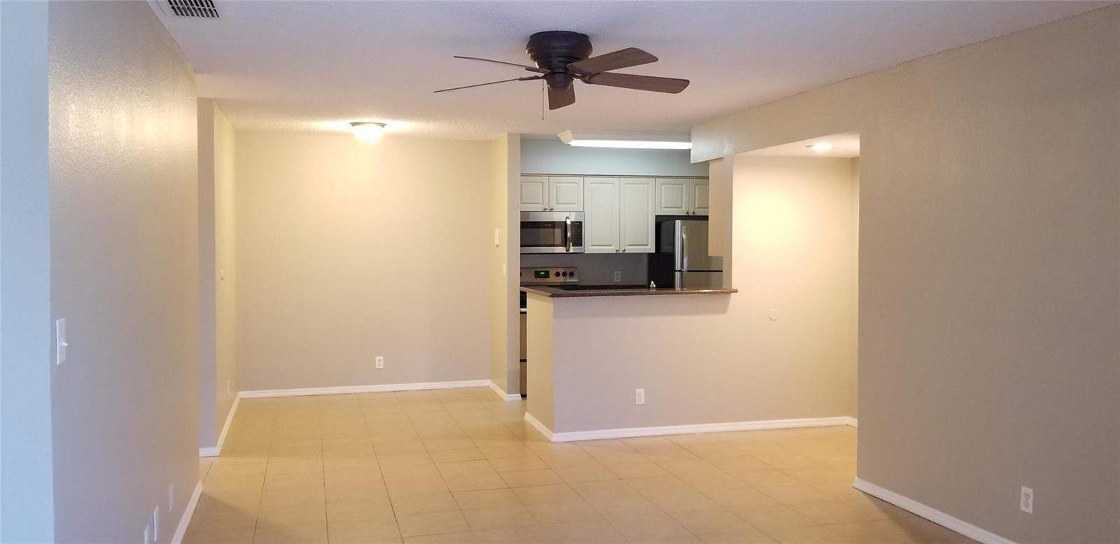An open-concept living and dining area features tile flooring, a ceiling fan, and a kitchen — 2846 S University Drive # 4205, Davie FL 33328, DAVIE, FL