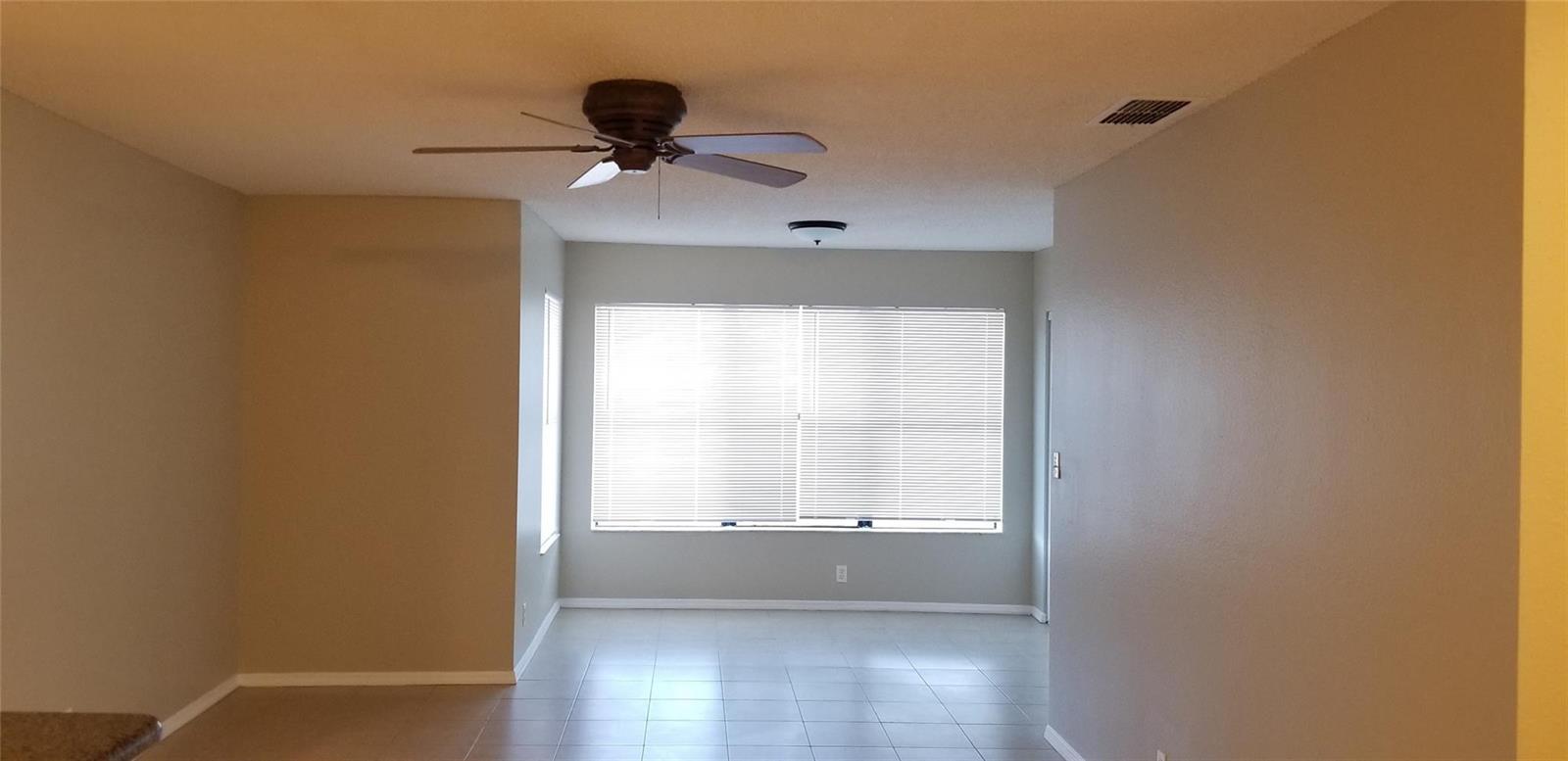 An empty room with light-colored tile flooring, a ceiling fan, and a large window — 2846 S University Drive # 4205, Davie FL 33328, DAVIE, FL